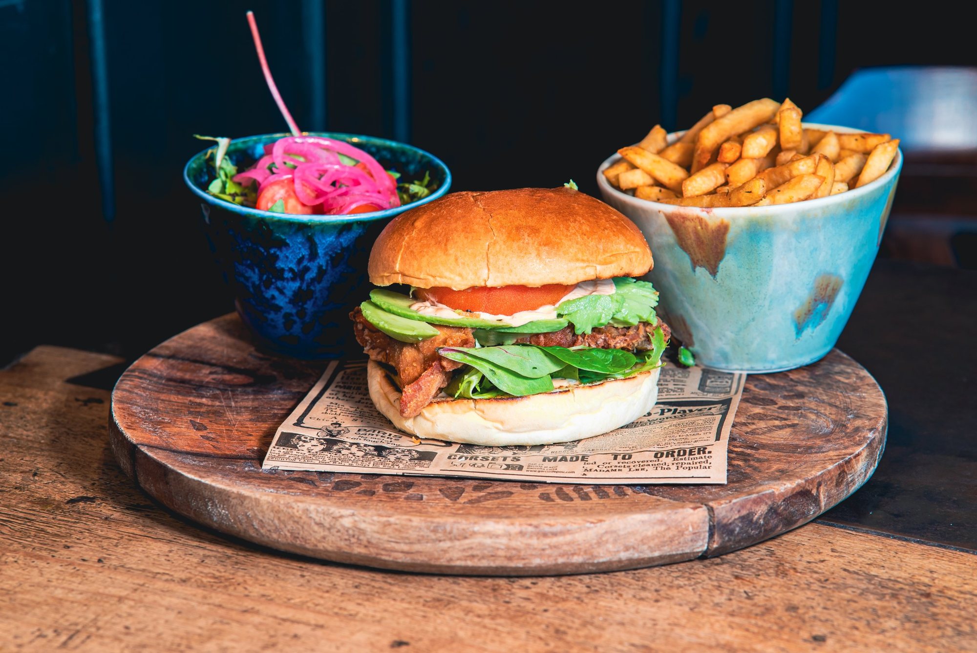 Photographe culinaire à Strasbourg : burger à l’avocat, frites et salade sur un plateau en bois