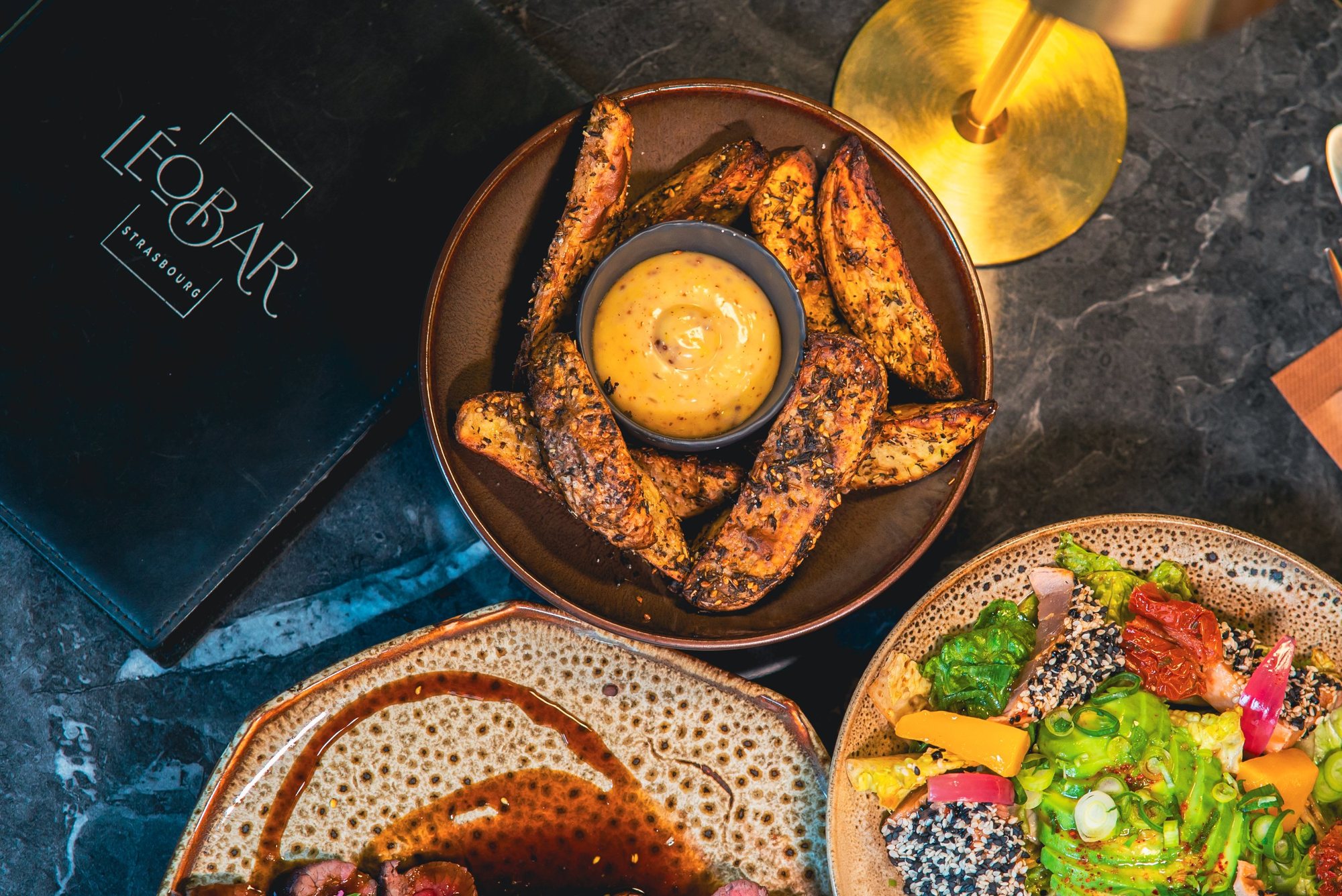 Photographe culinaire à Strasbourg : pommes de terre épicées, salade de thon et viande au Léo Bar