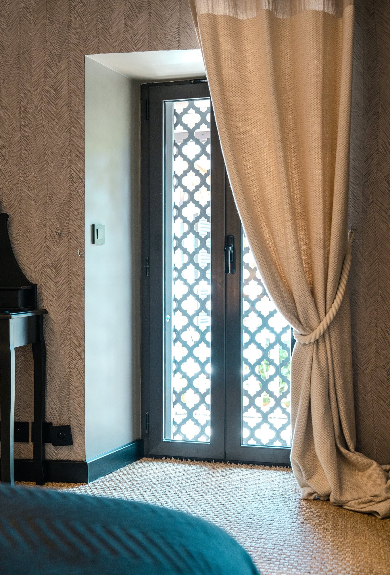 Photographe d’intérieur à Strasbourg : chambre, porte-fenêtre à moucharabieh et rideau en lin