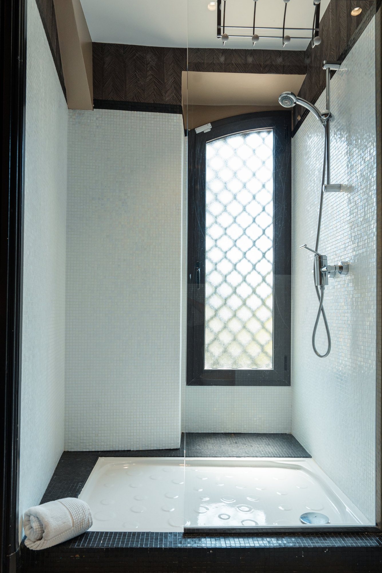 Photographe d’intérieur à Strasbourg : douche en mosaïque blanche et fenêtre à motif