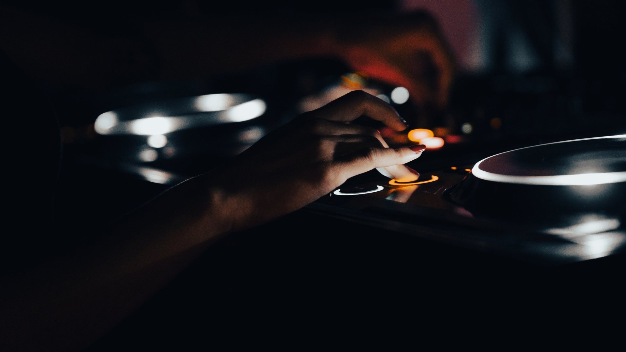 Photographe événementiel à Strasbourg : main d’une DJ sur les platines, lumières de la soirée