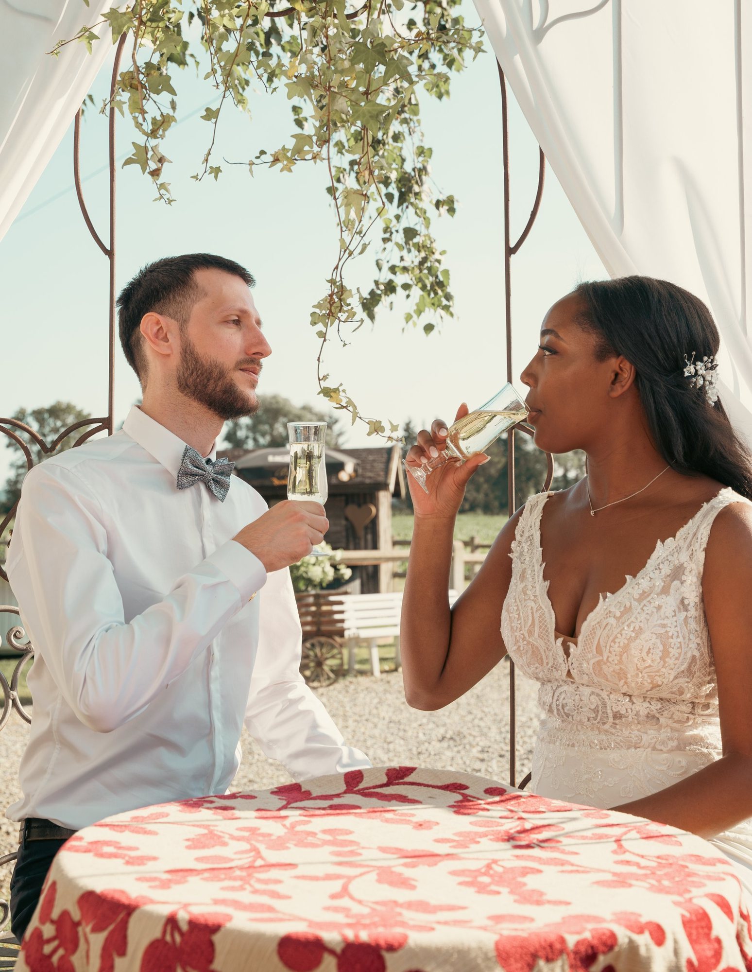 Photographe de mariage à Strasbourg : les mariés trinquent au champagne sous une tonnelle en fer forgé, en Alsace