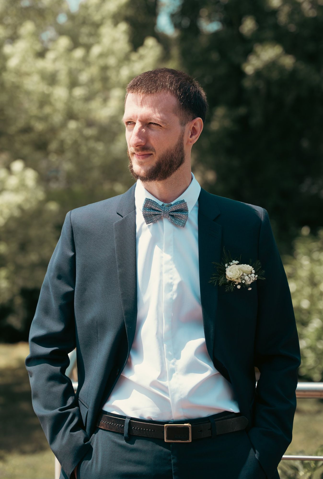 Photographe de mariage à Strasbourg : portrait d’un homme en costume bleu et nœud papillon, boutonnière de roses