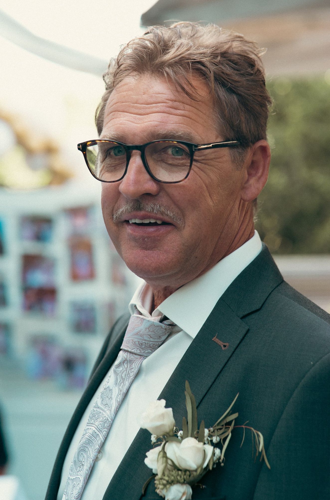 Photographe de mariage à Strasbourg : portrait d’un invité en costume avec boutonnière de roses