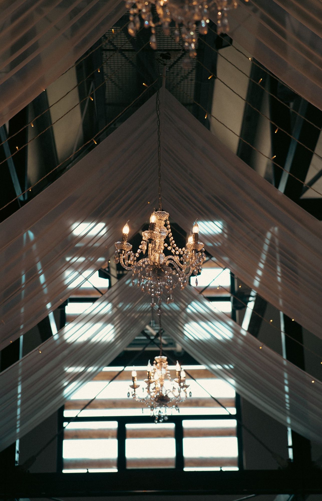 Photographe de mariage en Alsace : lustre et voiles blancs suspendus dans la salle de réception
