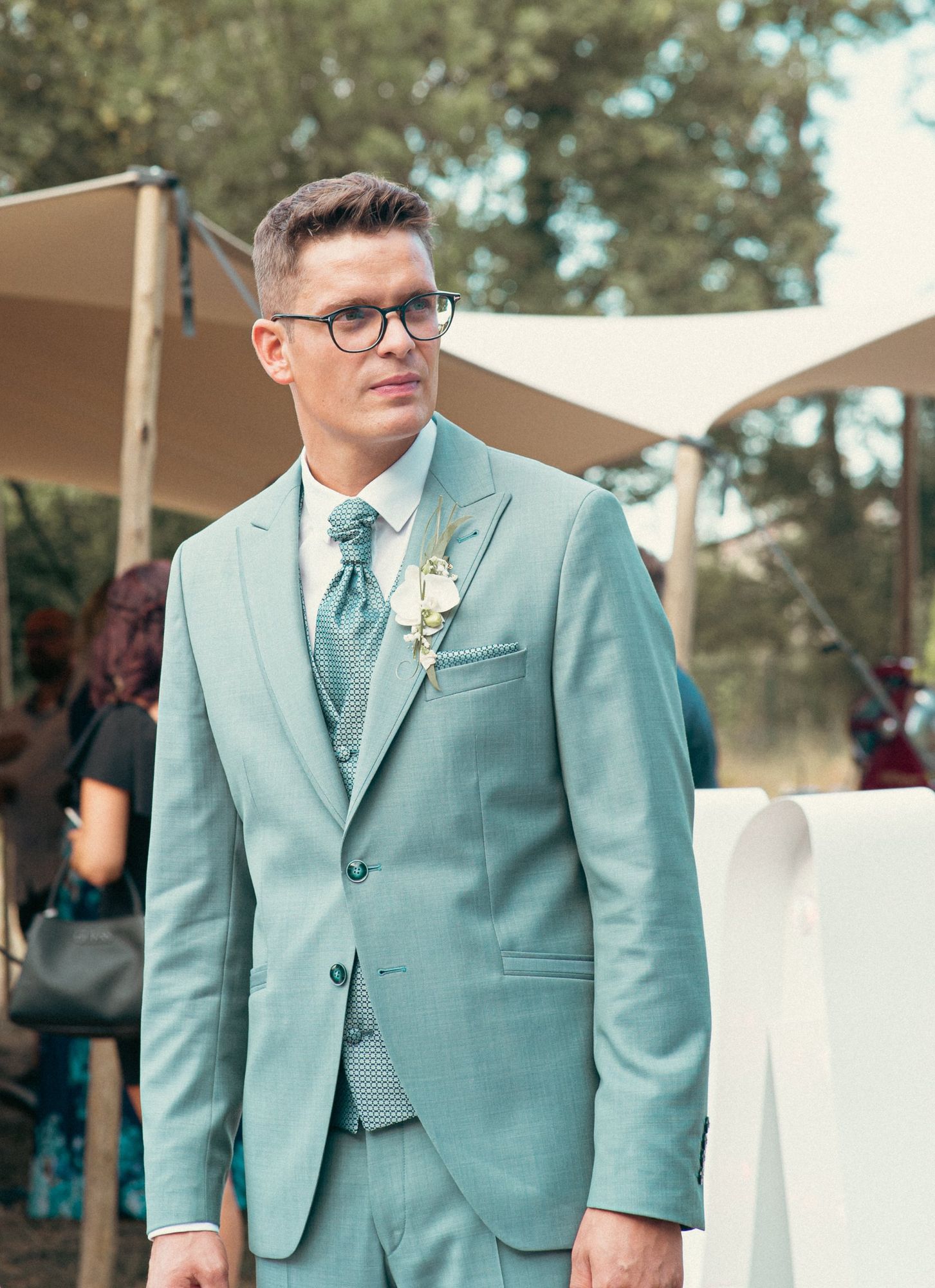 Photographe de mariage à Strasbourg : portrait du marié en costume vert d’eau avec boutonnière d’orchidée