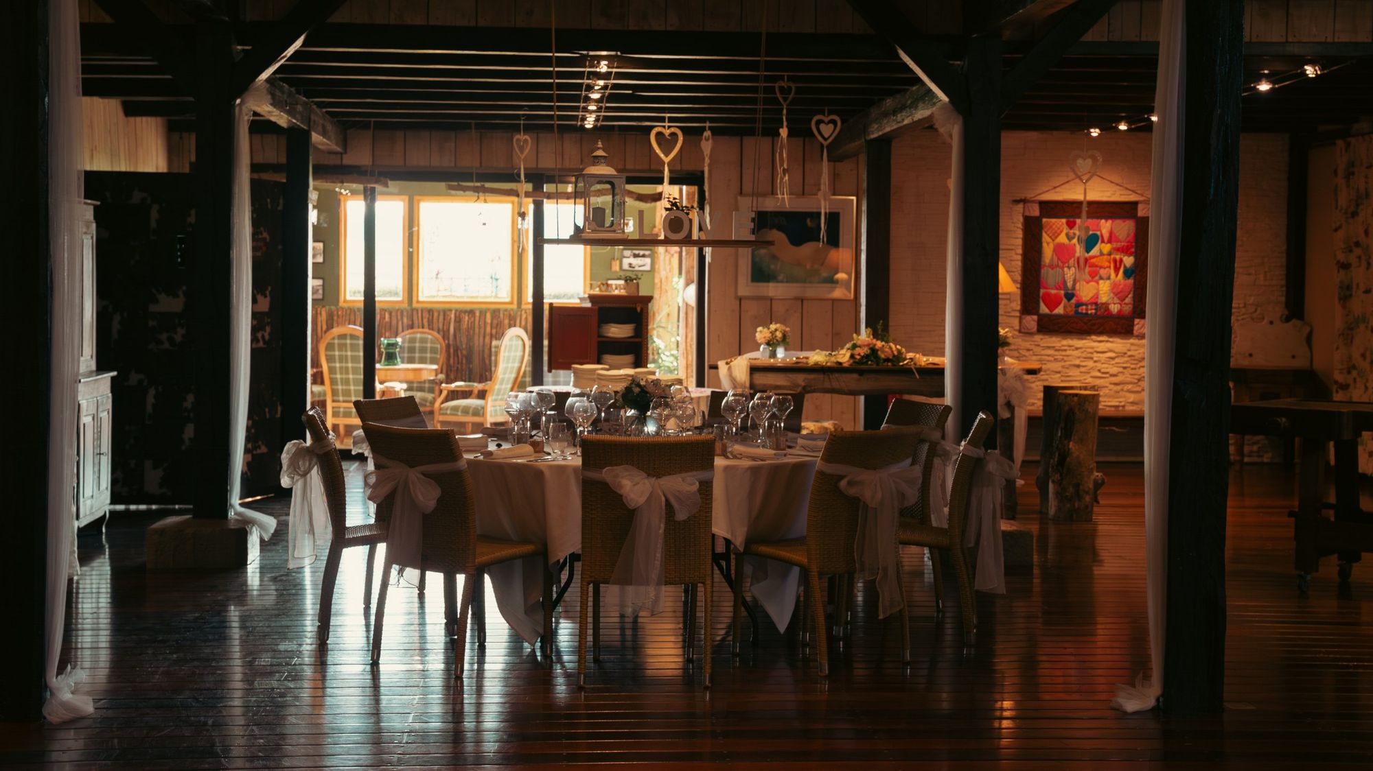 Photographe de mariage à Strasbourg : salle de réception en bois avec table ronde dressée et décoration cœurs