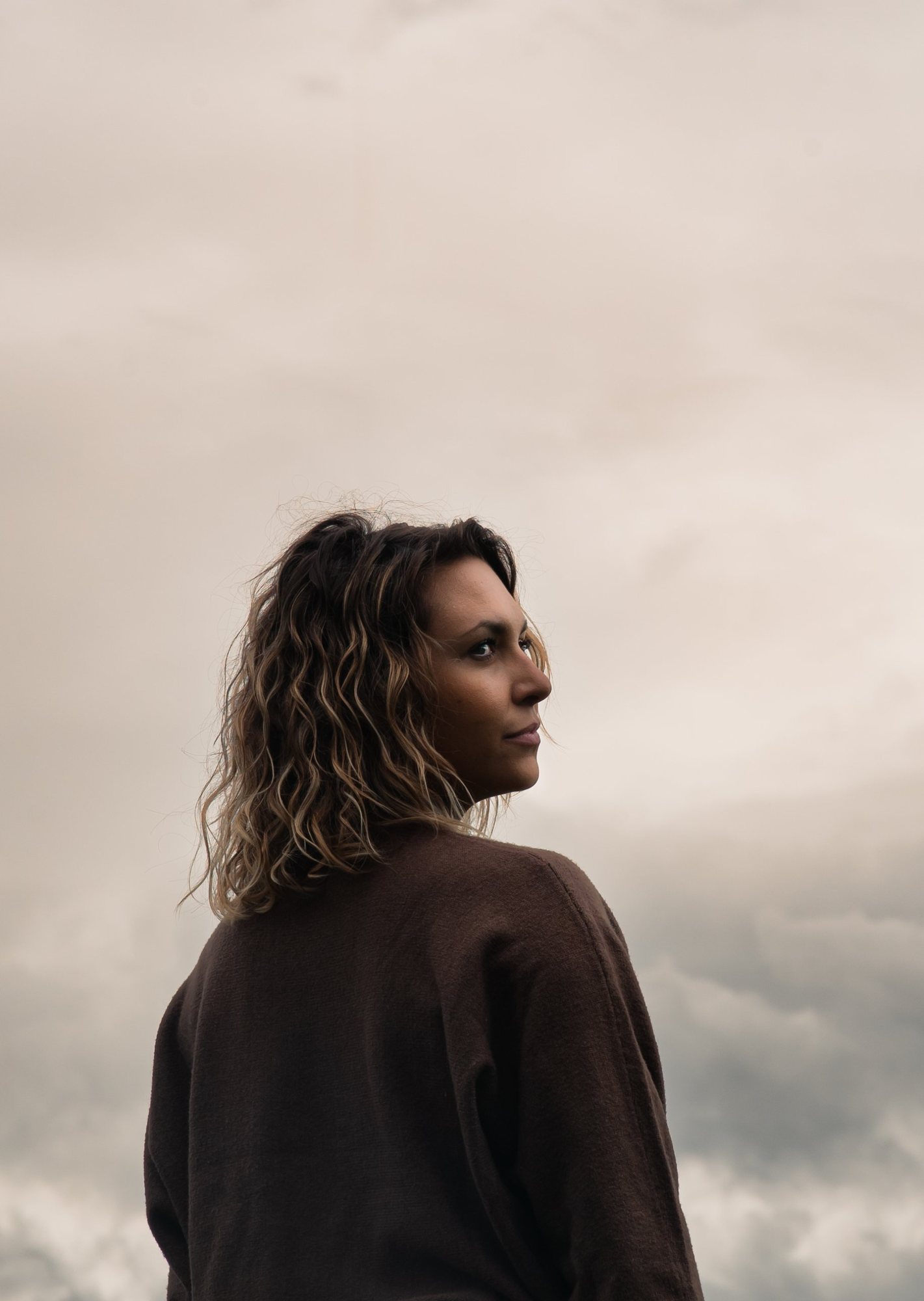Photographe portrait en Alsace : portrait de trois quarts dos d’une femme, regard vers l’horizon
