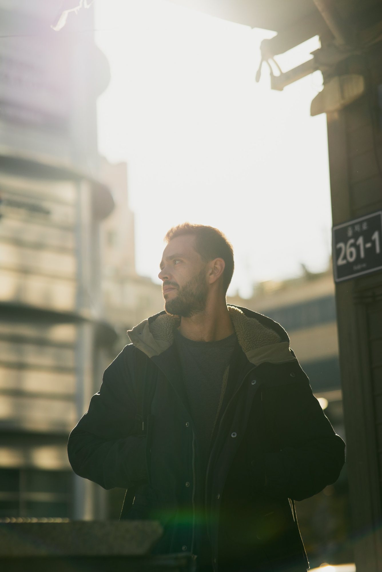 Photographe portrait : un homme en contre-jour dans une rue de Séoul, lumière dorée